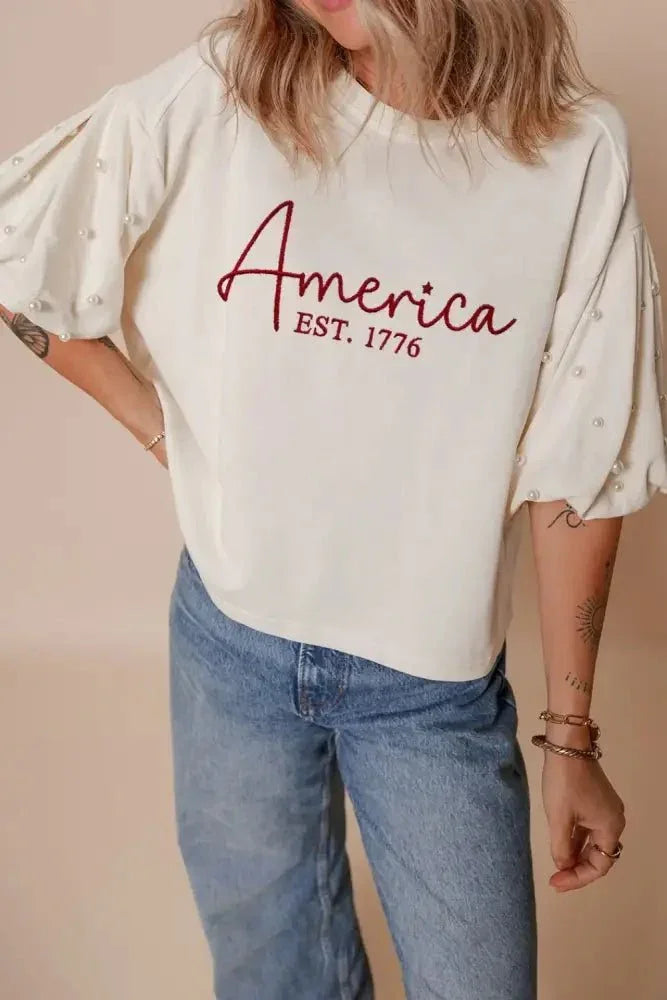 AMERICA EST 1776 Embroidered Pearl Beaded Sleeve T Shirt - Update AvenueT-ShirtsTrendsi1001008044689171001008044689177a2a57c9 - 995d - 4cdf - 8ffb - 337dcb1fbbed - Max - OriginWhite