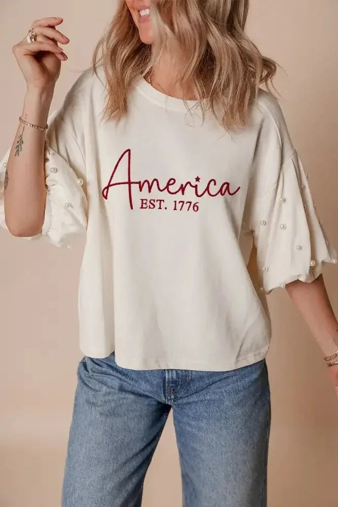 AMERICA EST 1776 Embroidered Pearl Beaded Sleeve T Shirt - Update AvenueT-ShirtsTrendsi100100804468917100100804468917054edfe3 - d564 - 44a0 - 89dc - 13a9458b2182 - Max - OriginWhite