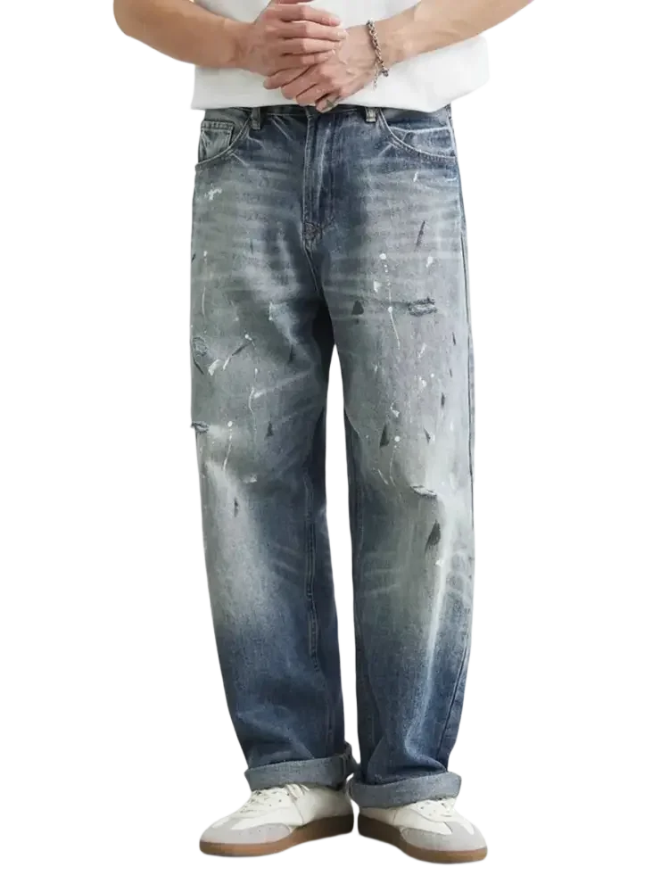 Distressed paint splatter relaxed fit men’s jeans with rolled cuffs and baggy style