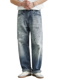 Distressed paint splatter relaxed fit men’s jeans with rolled cuffs and baggy style