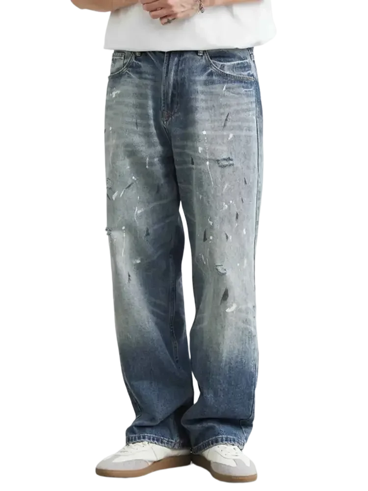 Men’s distressed paint splatter relaxed fit jeans with wide-leg design and faded wash