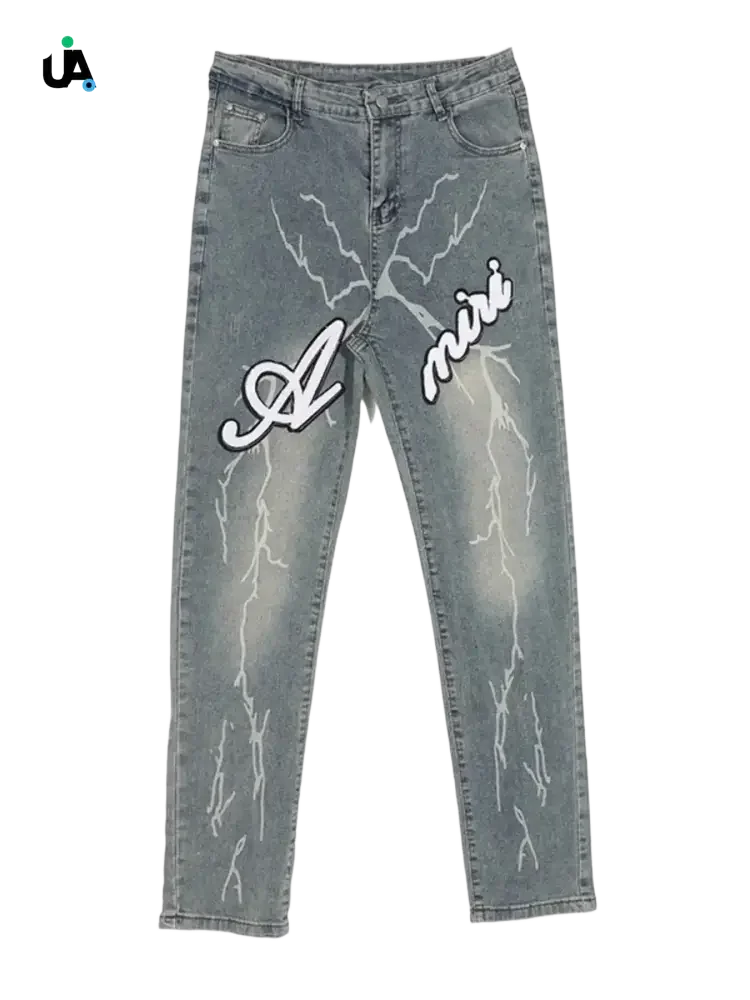Light-wash blue denim jeans with white lightning bolt designs and Amiri branding, size slim fit, plus fit jeans