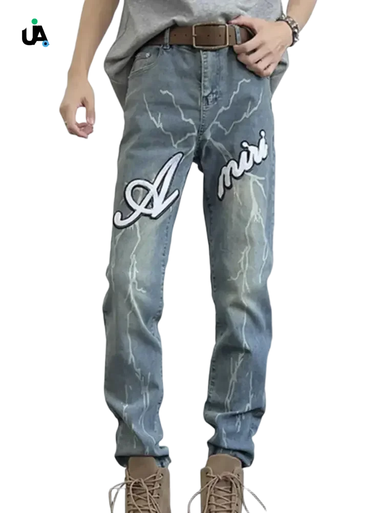 Men’s light blue distressed slim fit jeans with lightning bolt patterns and Amiri embroidery