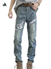 Men’s light blue distressed slim fit jeans with lightning bolt patterns and Amiri embroidery