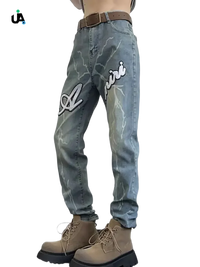 Light-wash denim jeans with white lightning bolt designs and Amiri branding, size slim fit plus