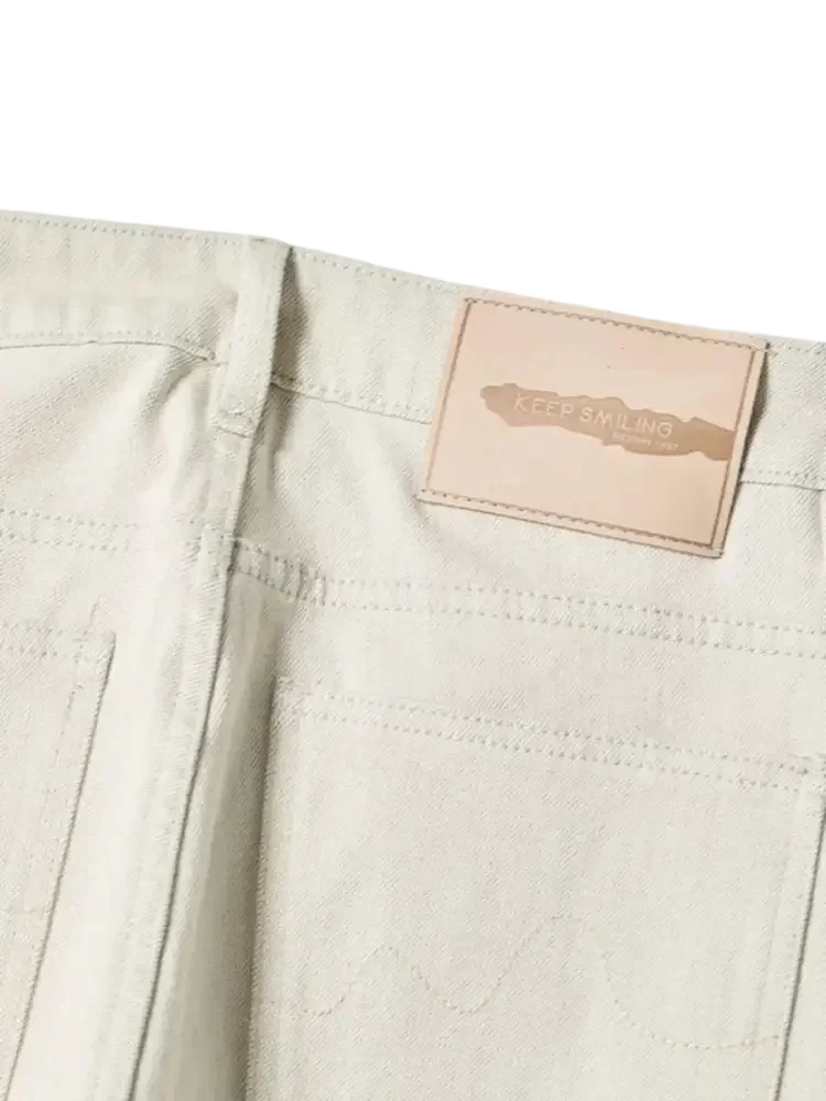 Light-colored wide leg jeans with tan leather patch from Trendsi men’s relaxed cream denim