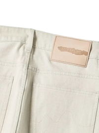 Light-colored wide leg jeans with tan leather patch from Trendsi men’s relaxed cream denim